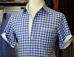 Blue short sleeve gingham shirt on a mannequin.