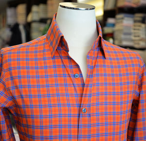 Orange and blue plaid shirt on a mannequin with a blurred background